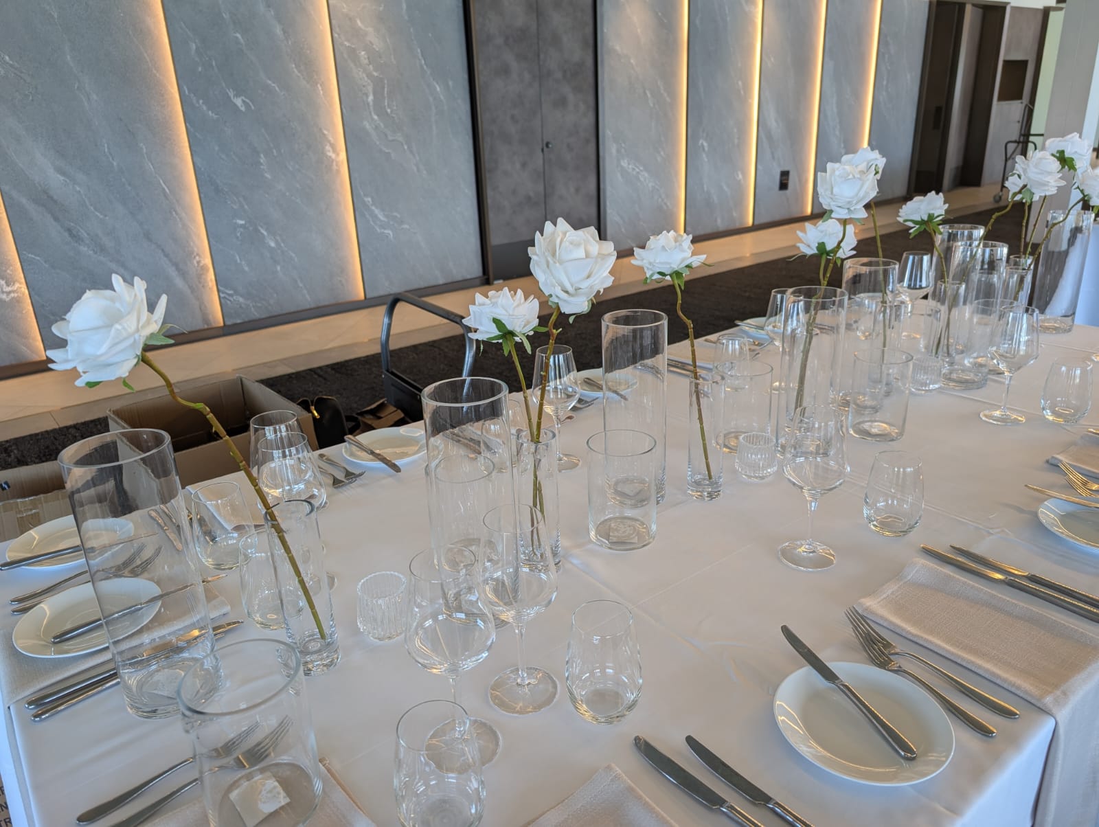 Modern long table with single stem roses in vases
